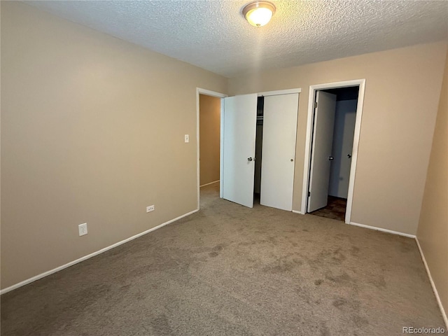unfurnished bedroom featuring carpet floors, a closet, and a textured ceiling