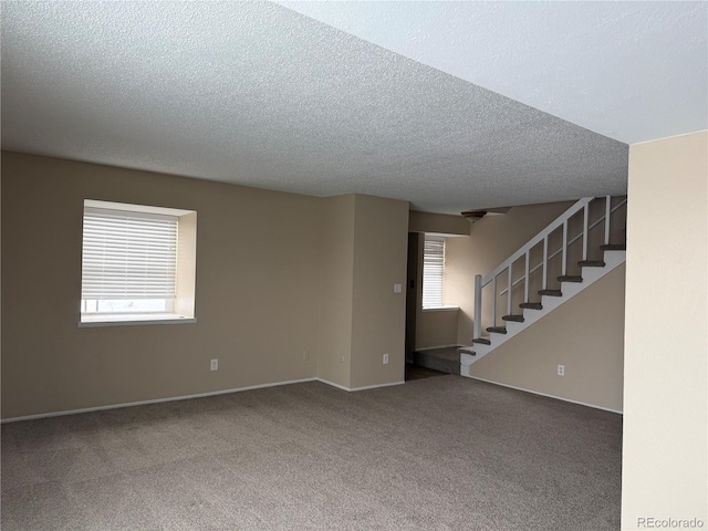 empty room featuring carpet and a textured ceiling