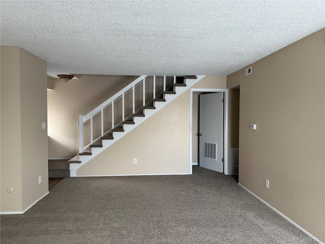 interior space with carpet floors and a textured ceiling
