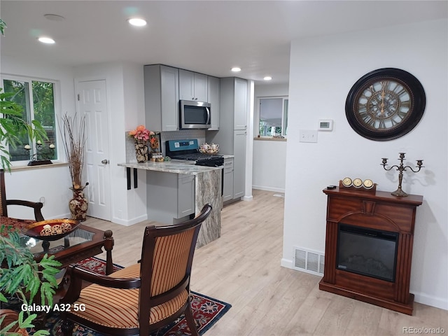 kitchen featuring appliances with stainless steel finishes, light wood-type flooring, visible vents, and gray cabinetry