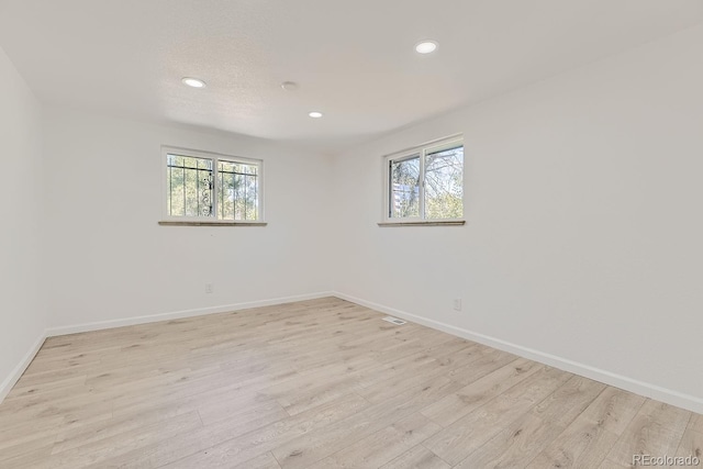 spare room with light wood-style floors, recessed lighting, and baseboards