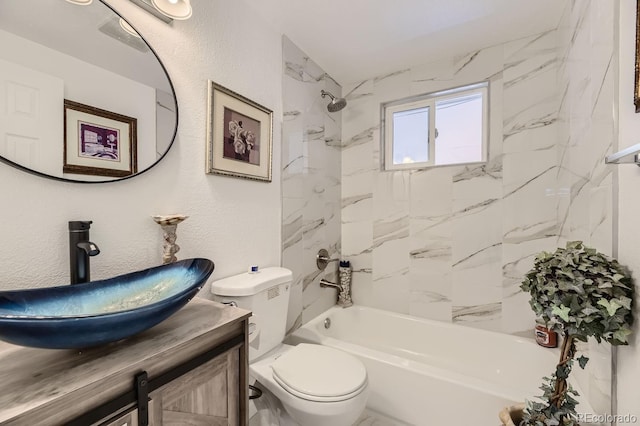 bathroom featuring a textured wall, vanity, toilet, and shower / bathtub combination