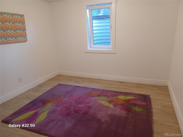 spare room with wood finished floors and baseboards