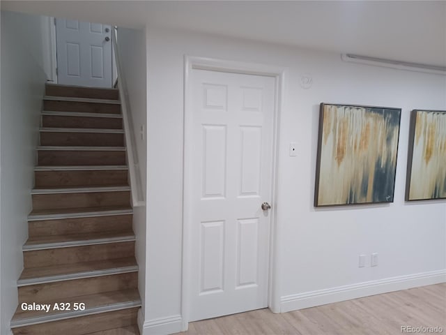 stairs featuring baseboards and wood finished floors