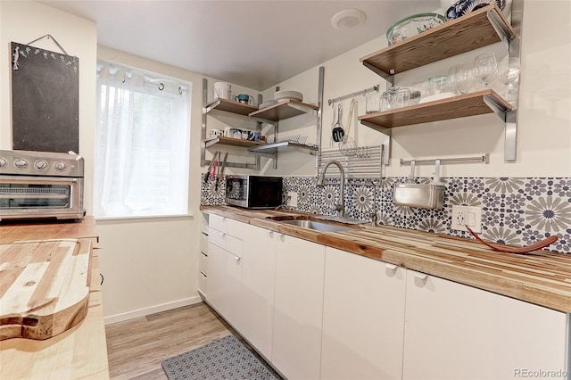 1434 Osceola St, Denver, CO 80204 - kitchen with stainless steel microwave, a sink, open shelves, and light wood-style floors