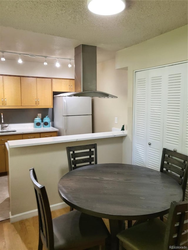 9105 E Lehigh Ave Unit 105, Denver, CO 80237 - dining space featuring light wood-type flooring, a textured ceiling, and rail lighting