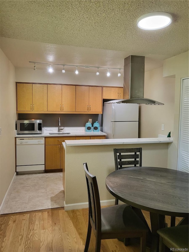9105 E Lehigh Ave Unit 105, Denver, CO 80237 - kitchen with white appliances, light countertops, extractor fan, baseboards, and a textured ceiling
