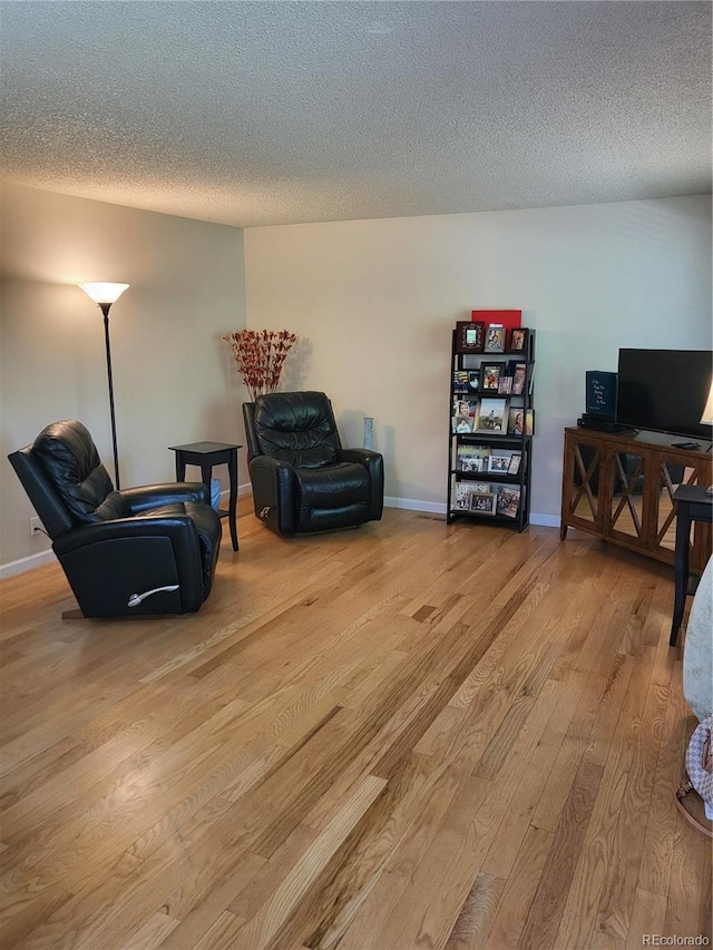 9105 E Lehigh Ave Unit 105, Denver, CO 80237 - sitting room featuring wood finished floors, a textured ceiling, and baseboards