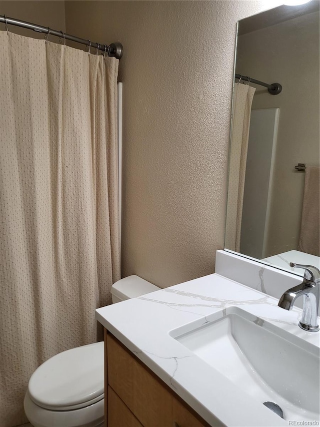 9105 E Lehigh Ave Unit 105, Denver, CO 80237 - full bathroom with a textured wall, vanity, and toilet