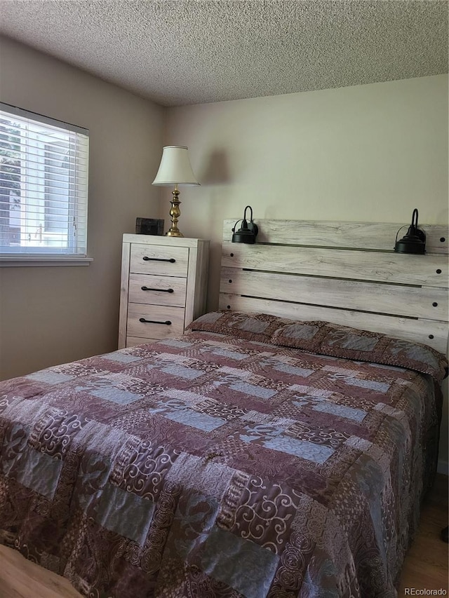 9105 E Lehigh Ave Unit 105, Denver, CO 80237 - bedroom featuring wood finished floors and a textured ceiling