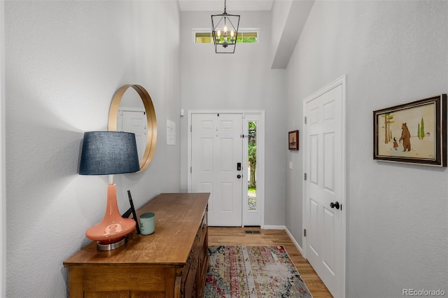 527 English Sparrow Trl, Highlands Ranch, CO 80129 - entryway featuring a high ceiling, light wood-style flooring, a chandelier, and baseboards