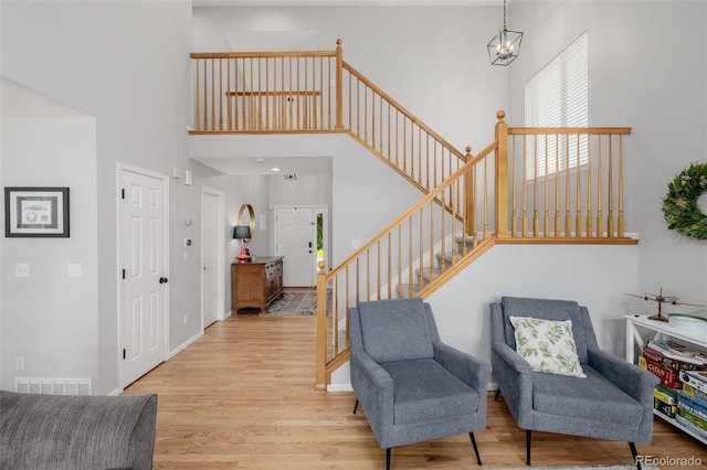 527 English Sparrow Trl, Highlands Ranch, CO 80129 - sitting room featuring a towering ceiling, stairway, wood finished floors, and baseboards