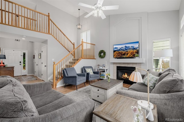 527 English Sparrow Trl, Highlands Ranch, CO 80129 - living room featuring healthy amount of natural light, stairs, a towering ceiling, light wood-style flooring, and a ceiling fan