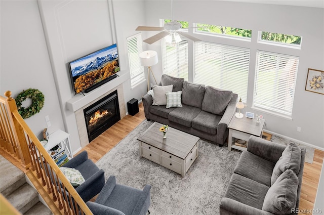 527 English Sparrow Trl, Highlands Ranch, CO 80129 - living area featuring wood finished floors, ceiling fan, a glass covered fireplace, and stairway