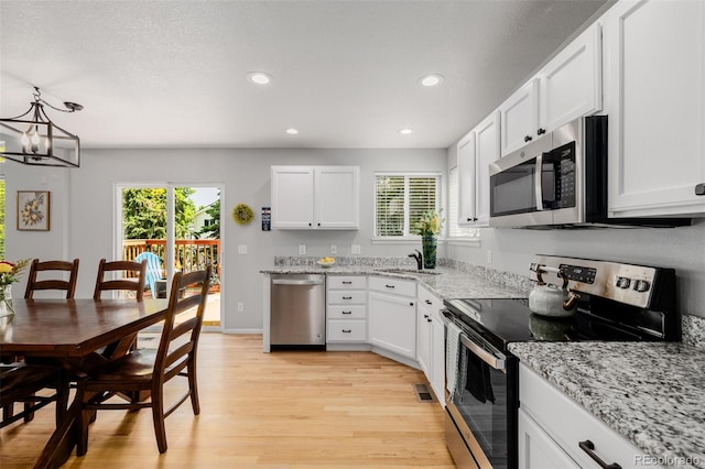 527 English Sparrow Trl, Highlands Ranch, CO 80129 - kitchen with appliances with stainless steel finishes, light wood-style floors, recessed lighting, white cabinets, and light stone counters