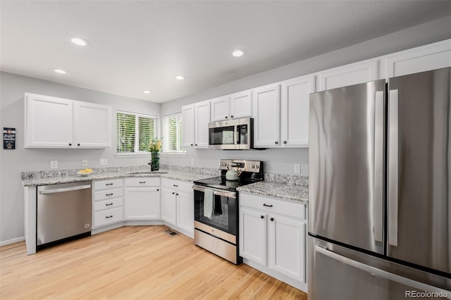 527 English Sparrow Trl, Highlands Ranch, CO 80129 - kitchen with appliances with stainless steel finishes, a sink, white cabinets, light wood-style floors, and recessed lighting