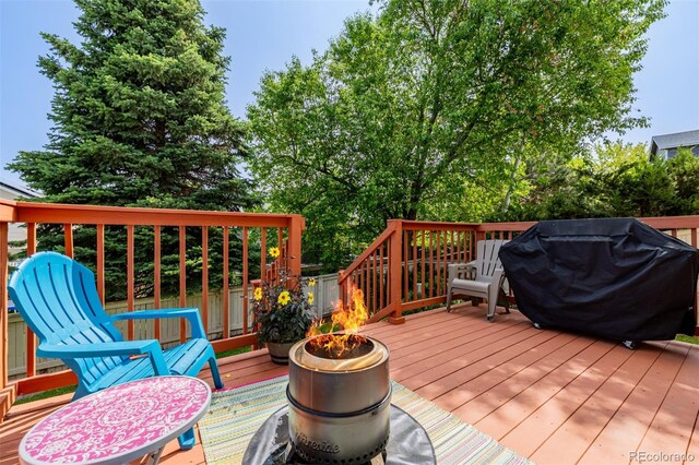 527 English Sparrow Trl, Highlands Ranch, CO 80129 - wooden deck featuring area for grilling and an outdoor fire pit