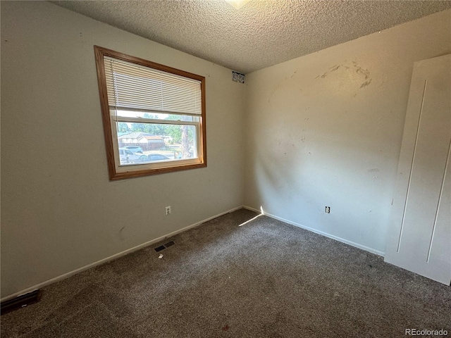 unfurnished room with carpet and a textured ceiling