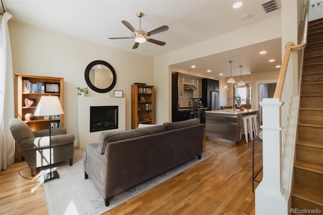 1008 River Park Rd, Buena Vista, CO 81211 - living room featuring light wood finished floors, ceiling fan, stairway, a fireplace, and recessed lighting