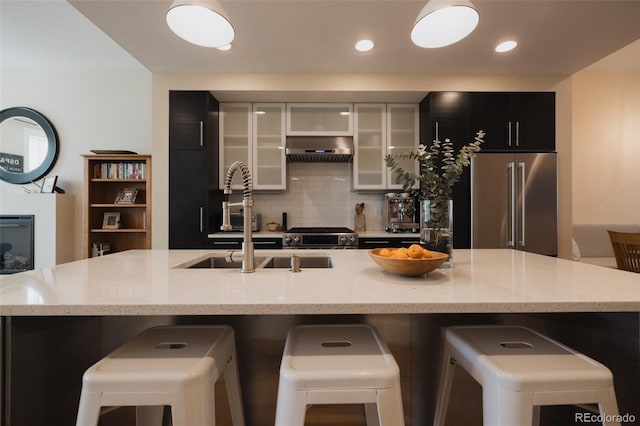 1008 River Park Rd, Buena Vista, CO 81211 - kitchen with stainless steel appliances, a breakfast bar area, backsplash, dark cabinetry, and recessed lighting