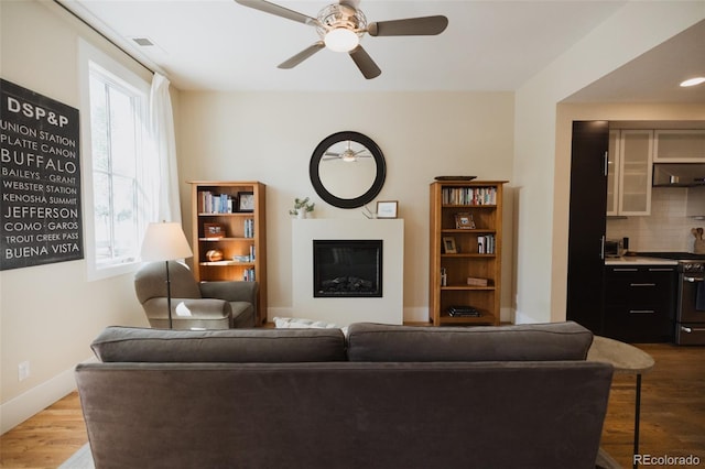 1008 River Park Rd, Buena Vista, CO 81211 - living room featuring a glass covered fireplace, wood finished floors, and ceiling fan