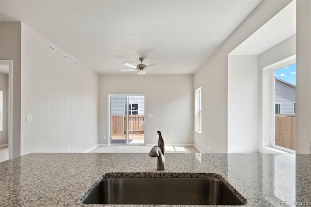 5913 Sawdust Dr, Brighton, CO 80601 - kitchen with a sink, stone countertops, a ceiling fan, and open floor plan