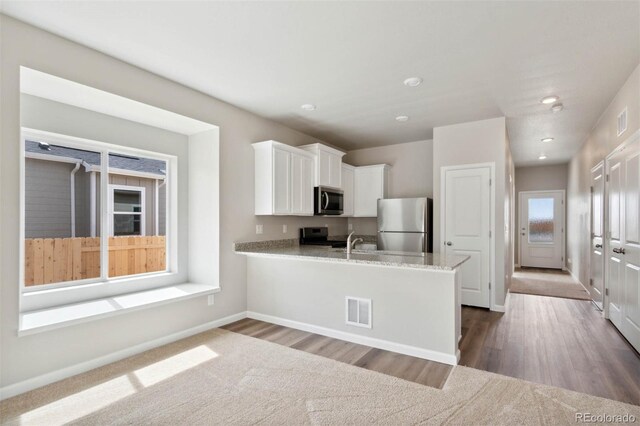 5913 Sawdust Dr, Brighton, CO 80601 - kitchen featuring stainless steel appliances, white cabinetry, baseboards, dark wood-style floors, and recessed lighting