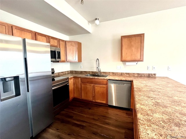 kitchen featuring kitchen peninsula, dark hardwood / wood-style flooring, sink, and stainless steel appliances