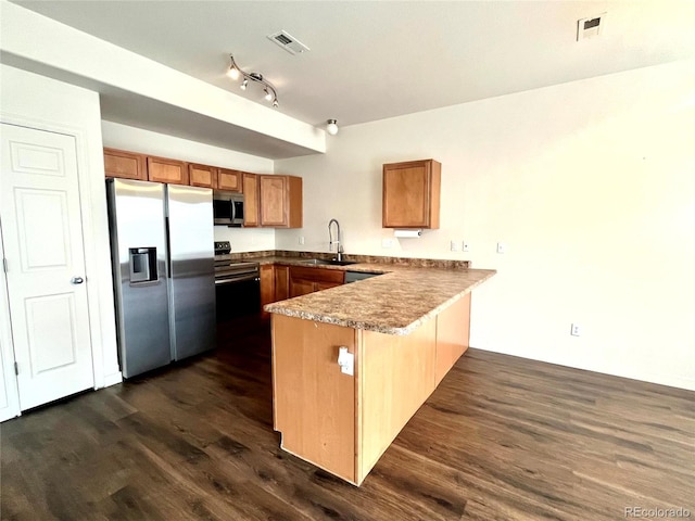 kitchen featuring kitchen peninsula, sink, stainless steel appliances, and dark hardwood / wood-style floors