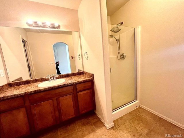 bathroom featuring vanity and a shower with shower door