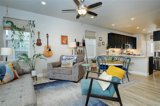 living room featuring ceiling fan and light hardwood / wood-style floors