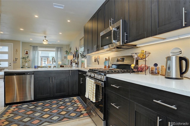 kitchen featuring ceiling fan, sink, stainless steel appliances, and light hardwood / wood-style flooring