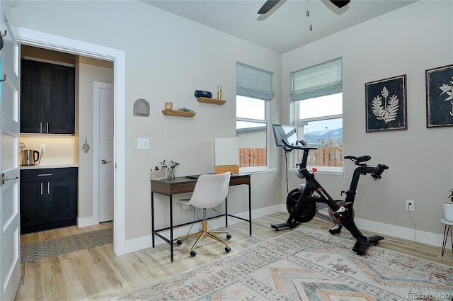 home office with light wood-type flooring and ceiling fan