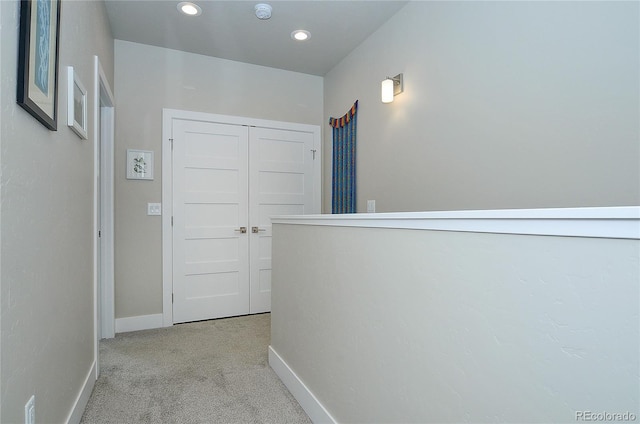 hallway featuring light colored carpet