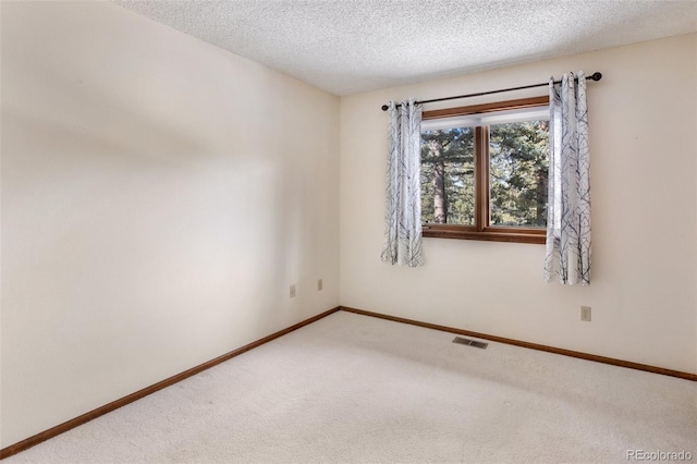 carpeted spare room featuring a textured ceiling