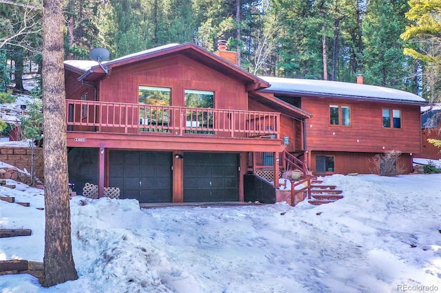 1003 Kings Crown Rd, Woodland Park, CO 80863 - view of front of house with a wooden deck, a chimney, and a garage