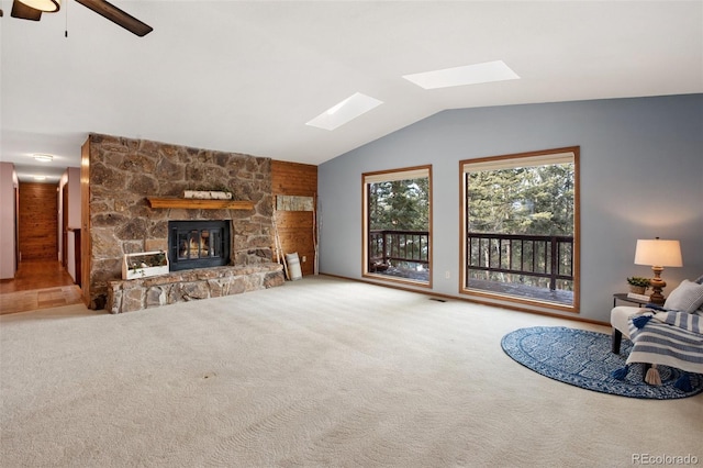1003 Kings Crown Rd, Woodland Park, CO 80863 - unfurnished living room with a stone fireplace, lofted ceiling with skylight, carpet flooring, and ceiling fan