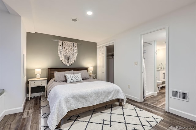 bedroom with an inviting chandelier, hardwood / wood-style flooring, a closet, and ensuite bathroom