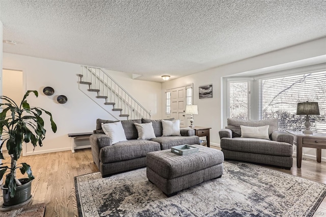 living room with light hardwood / wood-style floors and a textured ceiling