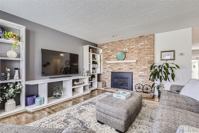 living room with hardwood / wood-style flooring, a fireplace, and a textured ceiling