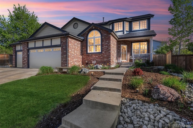 traditional home featuring covered porch, an attached garage, brick siding, and driveway