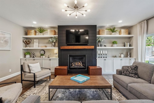 living room featuring a chandelier, wood finished floors, baseboards, a tiled fireplace, and recessed lighting