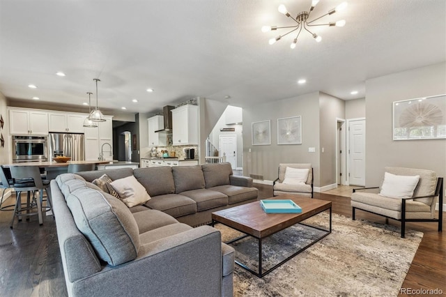 living area featuring a chandelier, dark wood-style flooring, recessed lighting, baseboards, and stairway