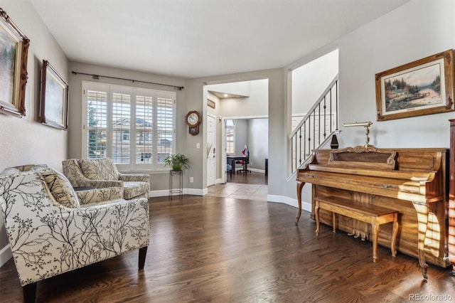 living area featuring wood finished floors, stairway, and baseboards