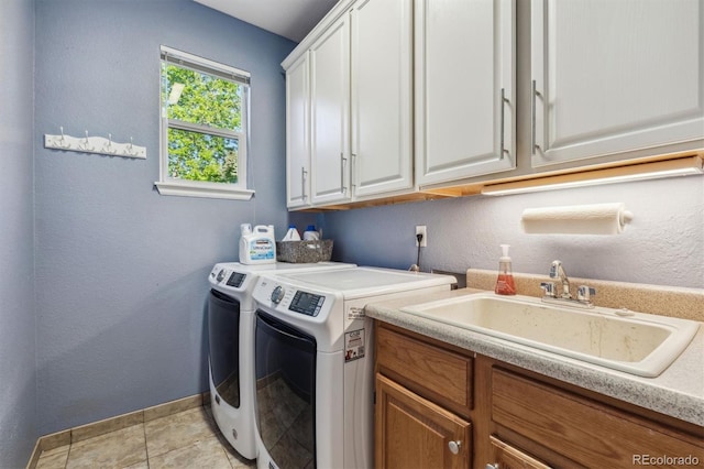 laundry area with washing machine and dryer, cabinet space, baseboards, and a textured wall