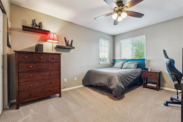 bedroom with light carpet, baseboards, and a ceiling fan