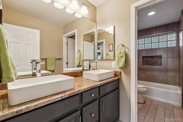 bathroom featuring toilet, double vanity, and wood finished floors