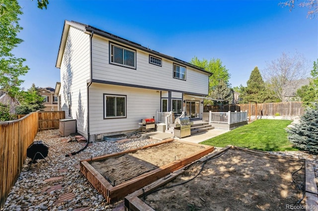 rear view of house featuring a deck, a vegetable garden, and a patio