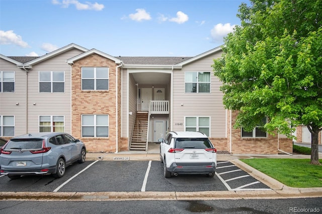11640 W 62nd Pl Unit 203, Arvada, CO 80004 - townhome / multi-family property with brick siding, stairway, and uncovered parking