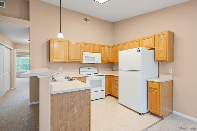 11640 W 62nd Pl Unit 203, Arvada, CO 80004 - kitchen with white appliances, a peninsula, light brown cabinets, light countertops, and a towering ceiling